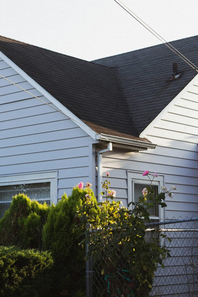 Homeowner reviewing roofing warranty papers beside shingle samples and a roof inspection checklist.